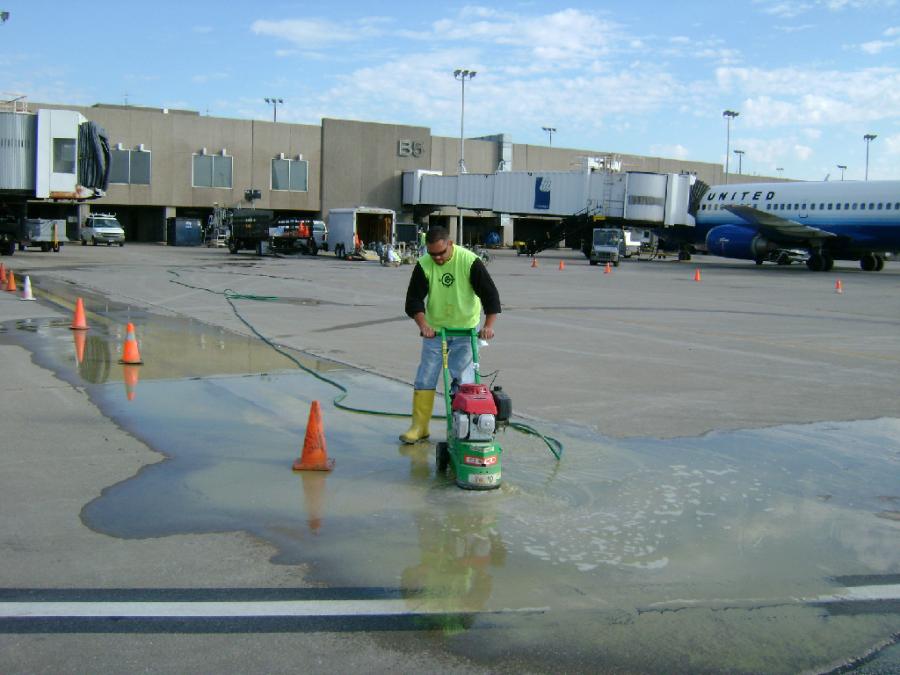 A person cleaning the floor water with an equipment