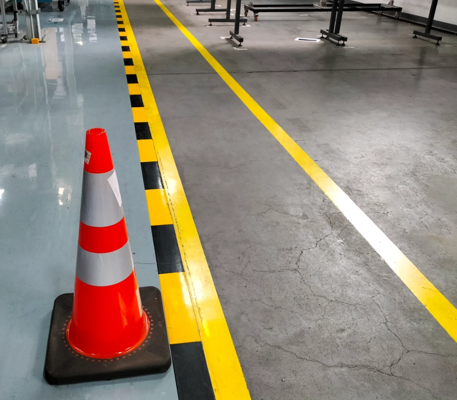 Orange traffic cone on factory floor.