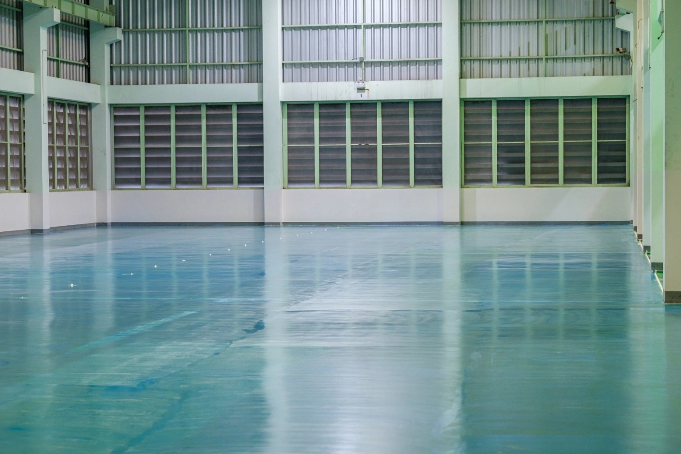 Empty factory floor with large windows.