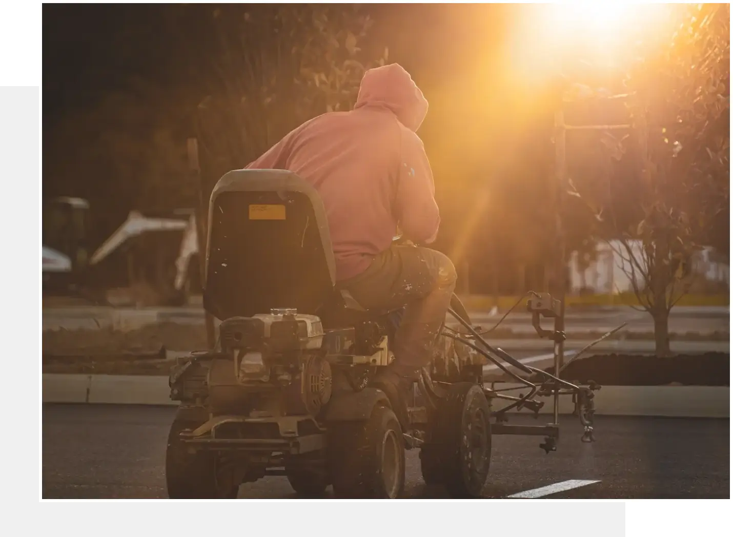 A person riding on the back of a lawn mower.